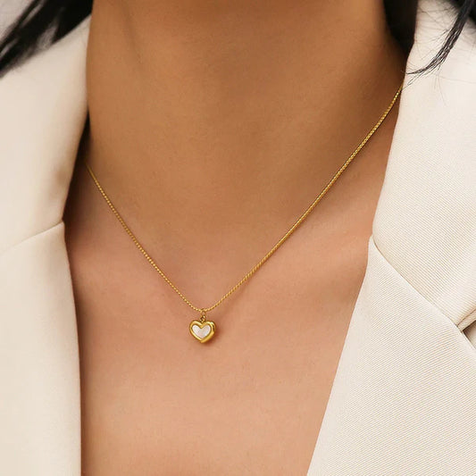 Gold Adore you necklace by everray worn by a person in a light-colored outfit.