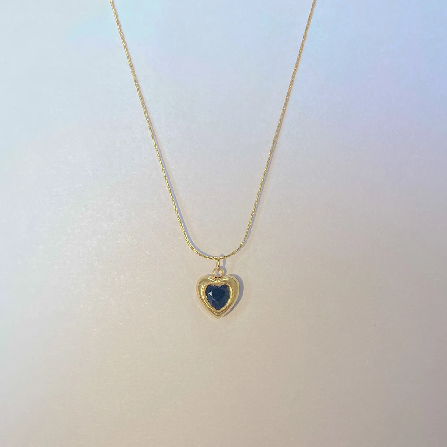 Adore you black necklace with a heart-shaped pendant on a light gradient background