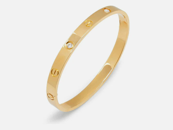 Gold bracelet with engraved letters on a white background