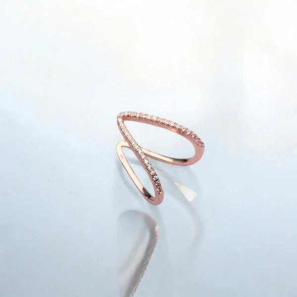 Rose gold ring with small stones on a light gray background