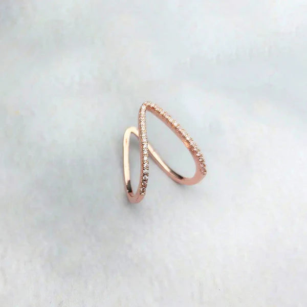 Rose gold ring with a subtle design on a light gray background