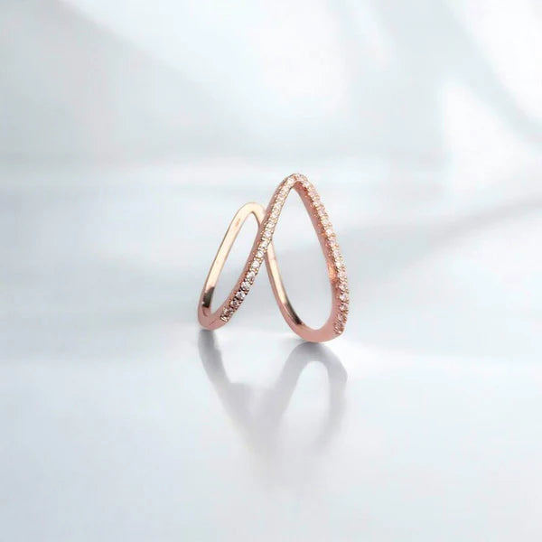 Two rose gold rings on a light gray background