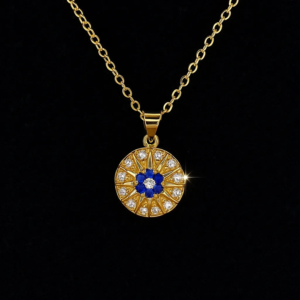 Gold evil eye pendant necklace with blue and white crystals in a circular chakra-style design on gold chain.