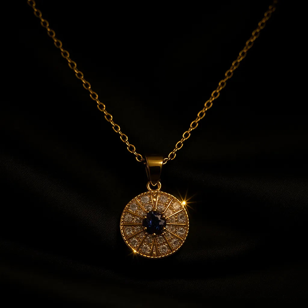 Gold evil eye pendant necklace with blue and white crystals in a circular chakra-style design on gold chain.