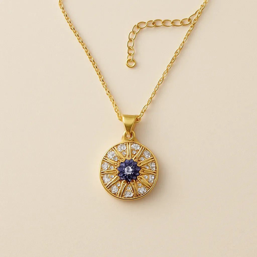 Gold evil eye pendant necklace with blue and white crystals in a circular chakra-style design on gold chain.