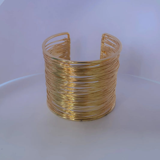 Gold wire cuff bracelet by everray on a white background