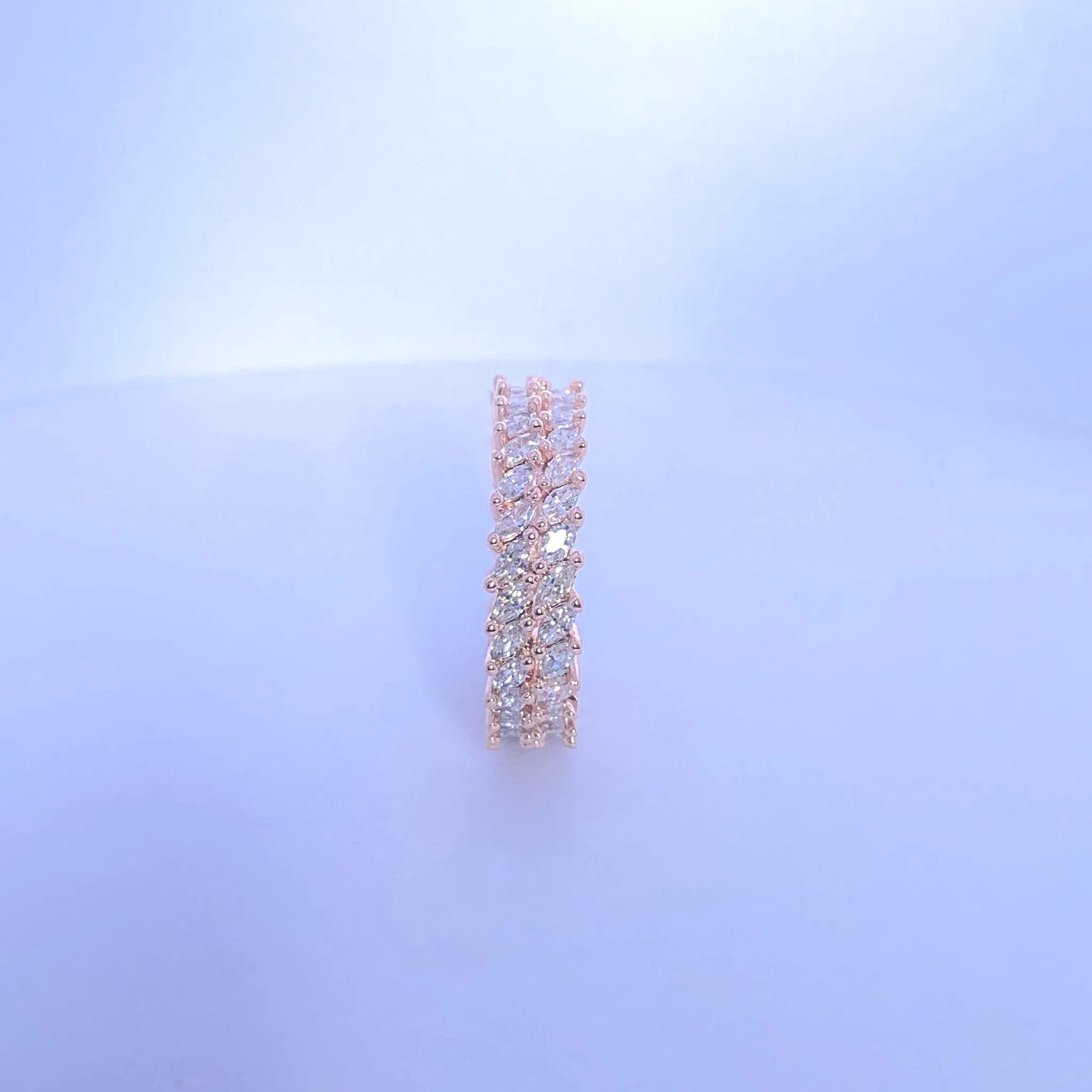 Rose gold earring with clear stones on a light blue background