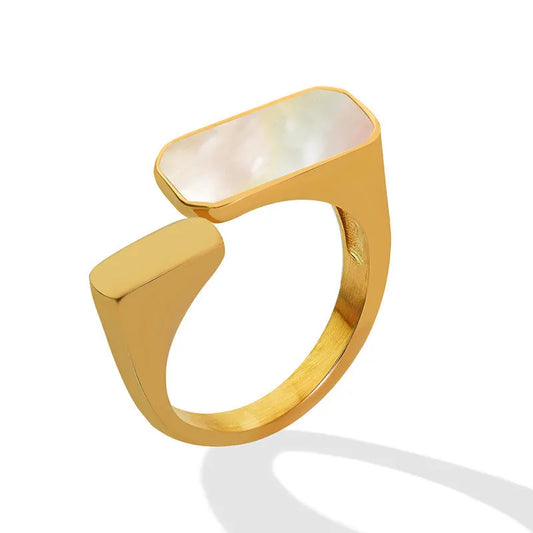 Gold ring with a central stone on a white background