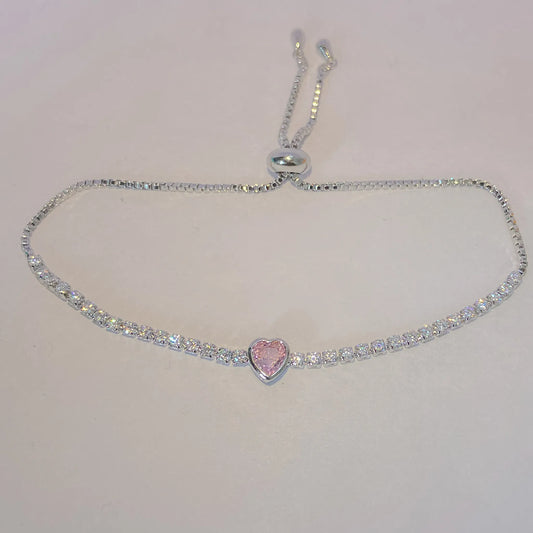 SIlver Tennis bracelet with a pink heart centerpiece by everray on a light gray background