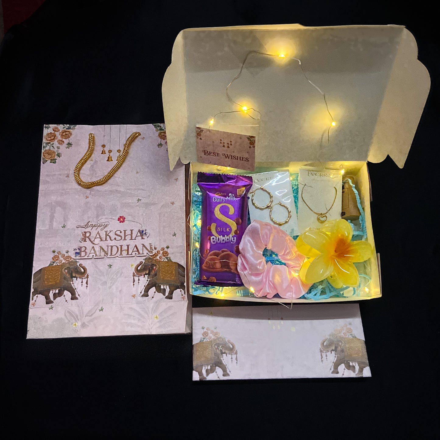 Rakhi Gift box withJewellery, Scrunchie , claw , Cadbury chocolate, and a card inside.