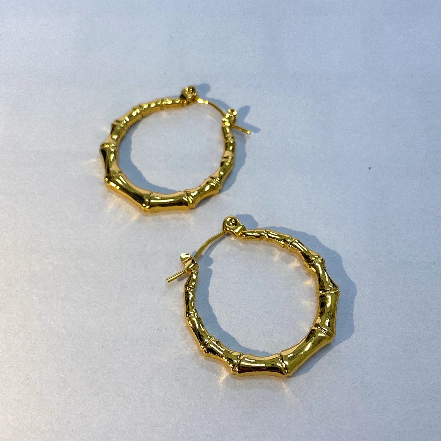Gold hoop earrings on a light gray background