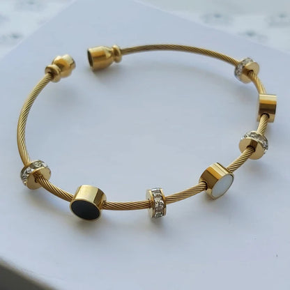 Gold bracelet with beads on a light gray background