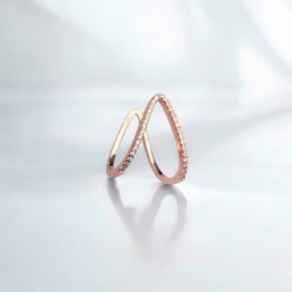 Two rose gold rings on a light gray background