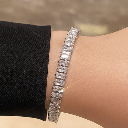 Silver bracelet with baguette-cut diamonds on a wrist against a neutral background