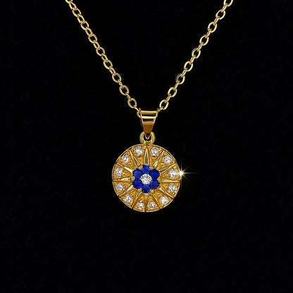 Gold evil eye pendant necklace with blue and white crystals in a circular chakra-style design on gold chain.