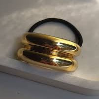 Gold hair ties on a white surface
