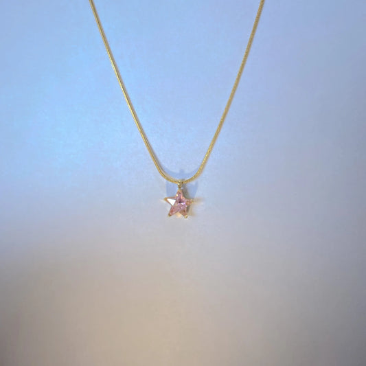 Necklace with a pink pendant on a gradient blue to beige background