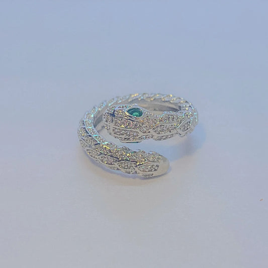 Silver snake-shaped ring with a green gemstone on a light gray background
