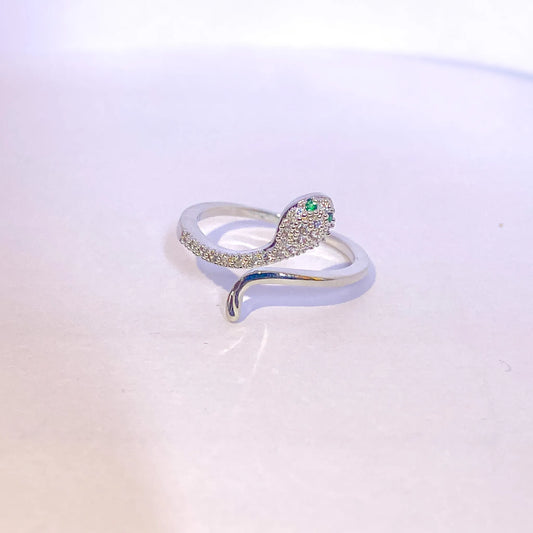 Silver ring with green gemstone on a light gradient background